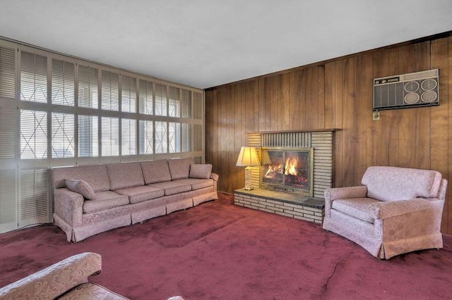 living area featuring carpet floors, a brick fireplace, and wooden walls