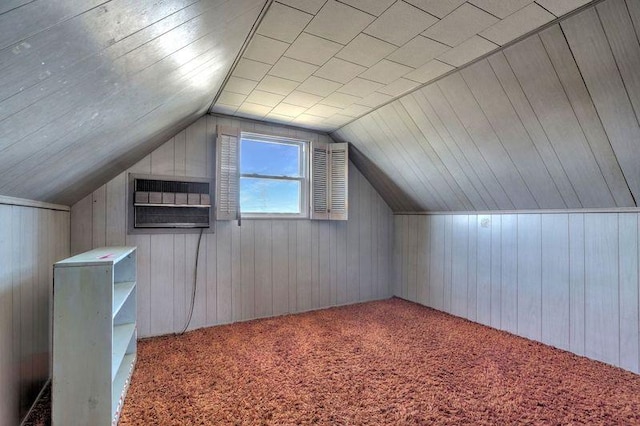 additional living space featuring vaulted ceiling, carpet floors, and wood walls