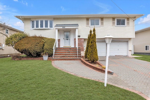 bi-level home featuring driveway, an attached garage, and a front lawn