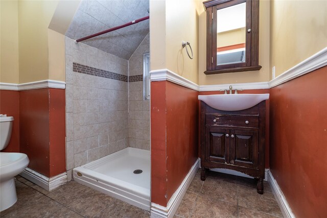 full bath featuring toilet, a shower stall, vanity, baseboards, and tile patterned floors