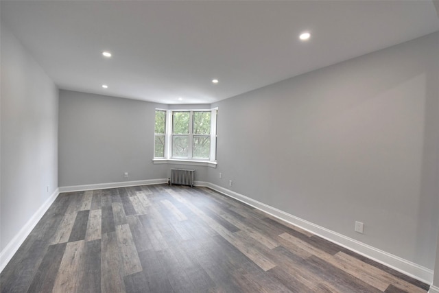 unfurnished room with radiator and dark hardwood / wood-style flooring