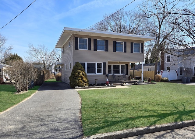 view of front of house featuring driveway, a front yard, and fence