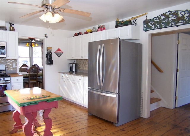 kitchen featuring light wood finished floors, tasteful backsplash, appliances with stainless steel finishes, and white cabinets