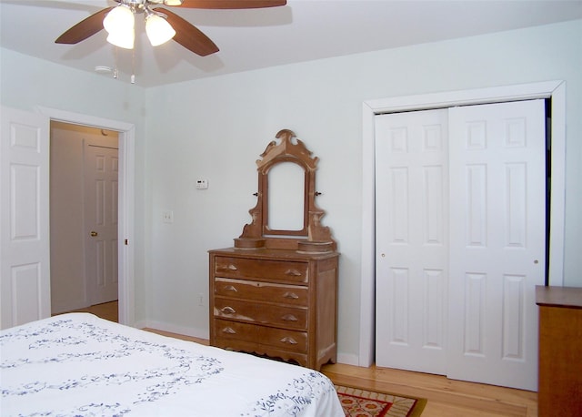 bedroom featuring light wood-style floors, a ceiling fan, and a closet