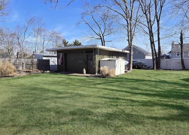 view of yard with fence, a storage unit, and an outbuilding