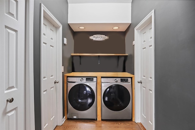 clothes washing area featuring light hardwood / wood-style flooring and separate washer and dryer