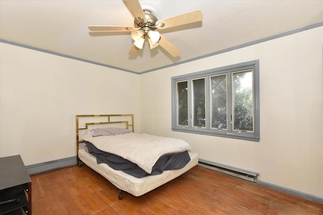 bedroom featuring a baseboard radiator, ornamental molding, ceiling fan, and wood-type flooring