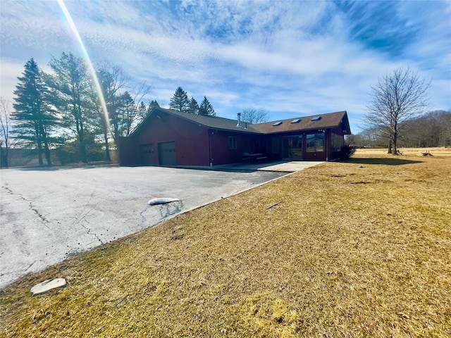 view of side of home with a garage and a lawn