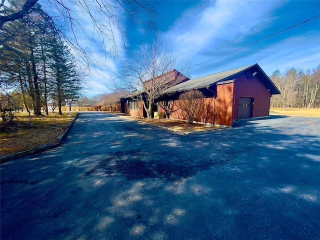 view of property exterior featuring aphalt driveway and a garage