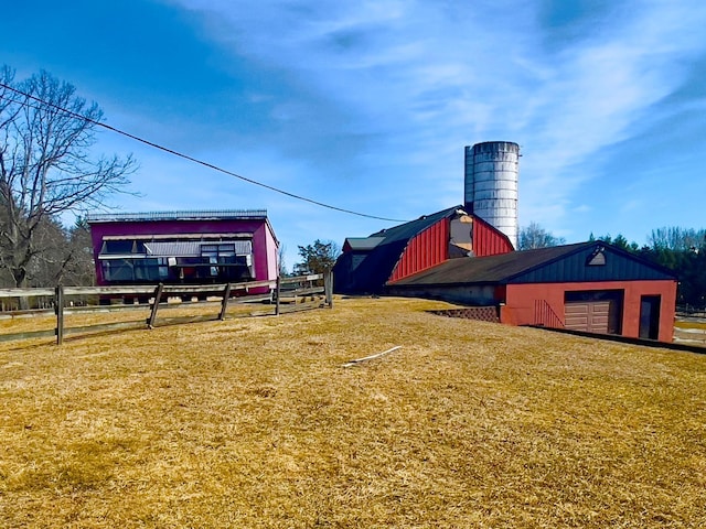 view of yard with an outdoor structure, fence, a garage, and a barn