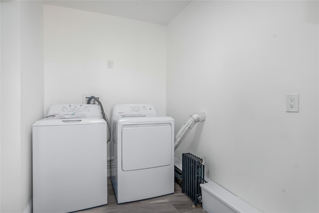 laundry room featuring independent washer and dryer, radiator, and light wood-type flooring