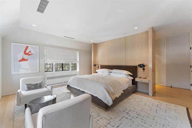 bedroom with recessed lighting, radiator, visible vents, and light wood finished floors