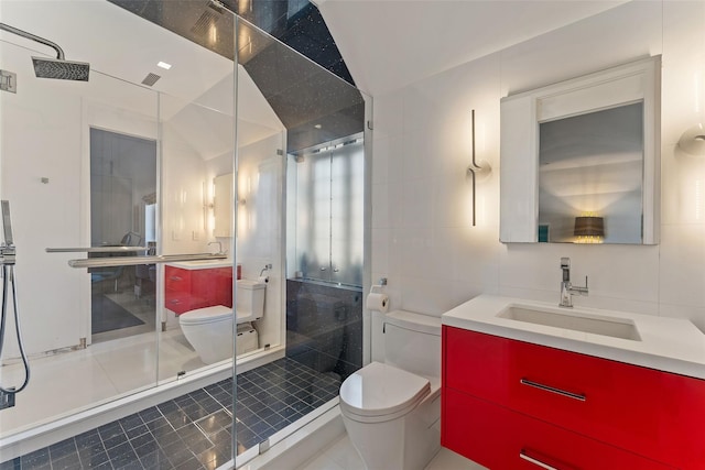 bathroom featuring toilet, tile patterned flooring, vanity, a shower stall, and tile walls