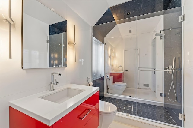 full bath featuring tile walls, backsplash, toilet, a stall shower, and vanity