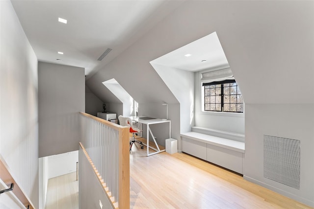 bonus room with visible vents, vaulted ceiling, and light wood finished floors