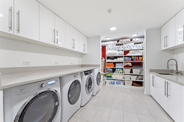 laundry area featuring washer and dryer, laundry area, a sink, and light tile patterned floors