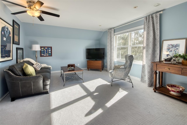 living area with baseboards, ceiling fan, vaulted ceiling, and light carpet