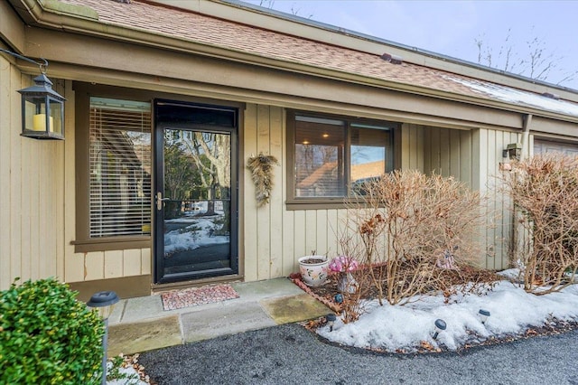 property entrance featuring a shingled roof