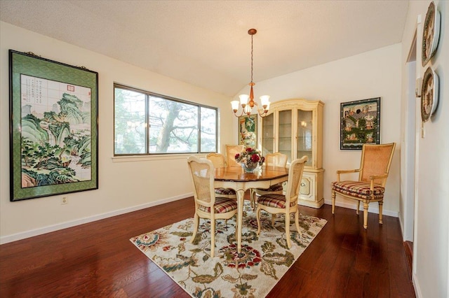 dining room featuring baseboards, a chandelier, vaulted ceiling, and dark wood-style flooring