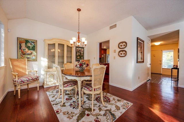 dining area with a notable chandelier, visible vents, baseboards, vaulted ceiling, and wood-type flooring