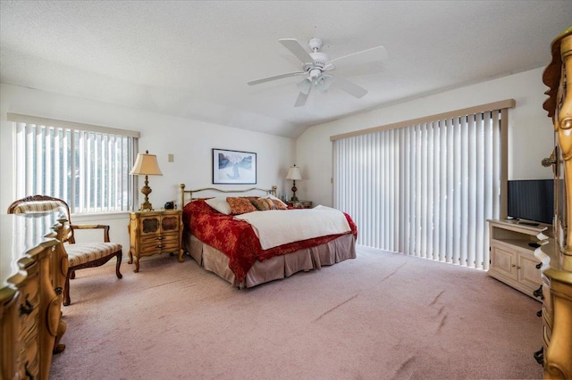 bedroom with a ceiling fan, lofted ceiling, carpet flooring, and a textured ceiling