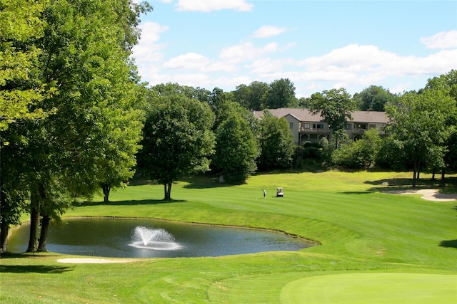 view of community featuring a yard, golf course view, and a water view