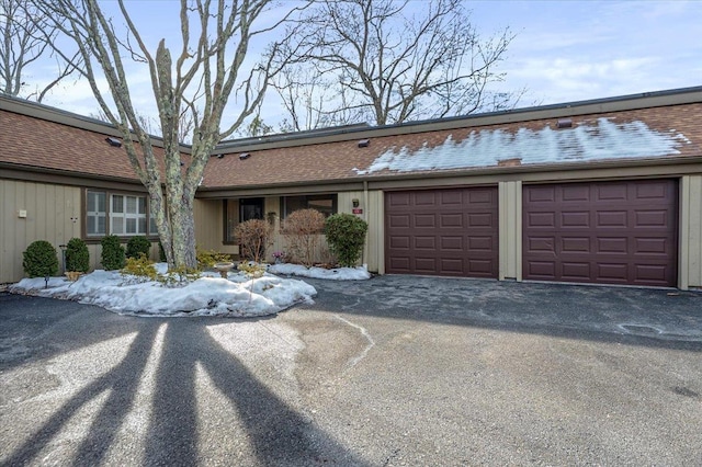 townhome / multi-family property featuring aphalt driveway and a garage