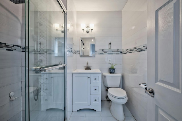 bathroom featuring tile walls, toilet, a shower stall, vanity, and tile patterned floors