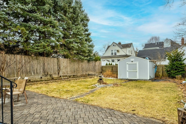 view of yard featuring a patio area, an outdoor structure, a fenced backyard, and a storage shed