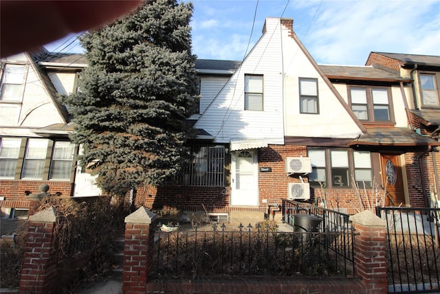 view of front of property with a fenced front yard, brick siding, a chimney, and roof with shingles