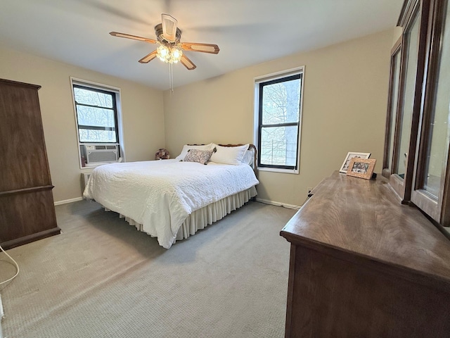 bedroom featuring ceiling fan, baseboards, cooling unit, and light colored carpet