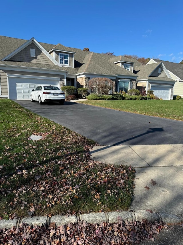 view of front of house with a garage, driveway, and a front lawn