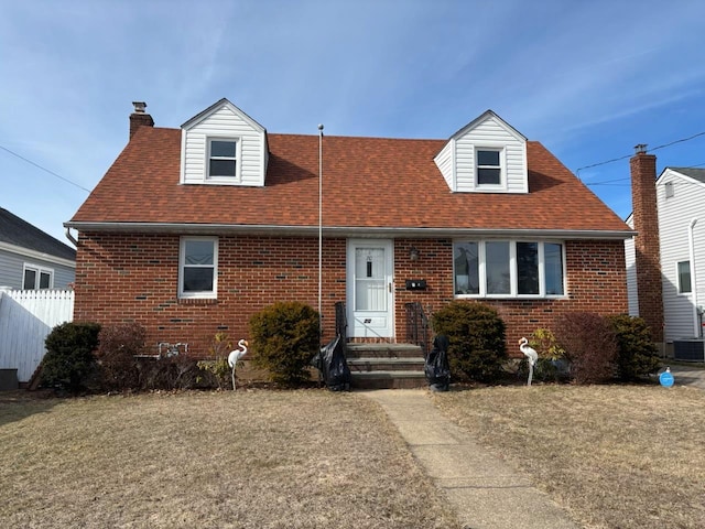 cape cod home with a front lawn