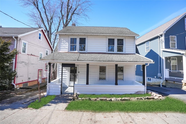 view of front of house featuring a porch, a shingled roof, and a chimney