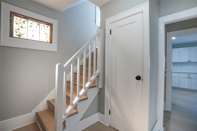 stairs with baseboards and wood finished floors