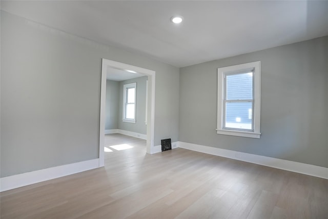 spare room with baseboards and wood finished floors