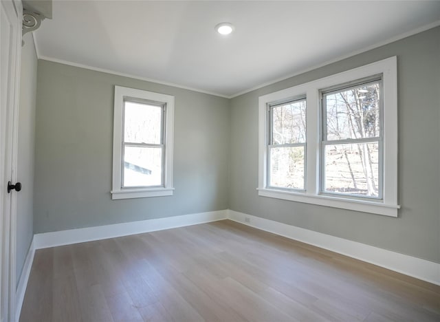 spare room featuring ornamental molding, wood finished floors, and baseboards