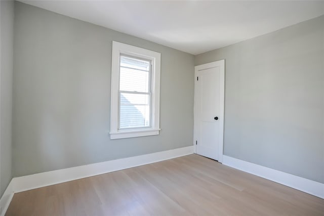 spare room featuring light wood finished floors and baseboards