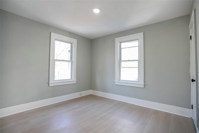 spare room featuring baseboards and wood finished floors