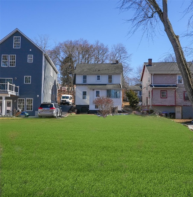 rear view of house featuring a lawn