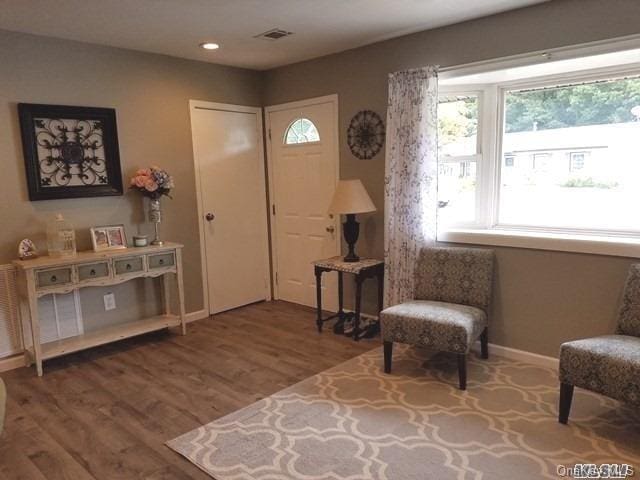 living area featuring recessed lighting, wood finished floors, visible vents, and baseboards