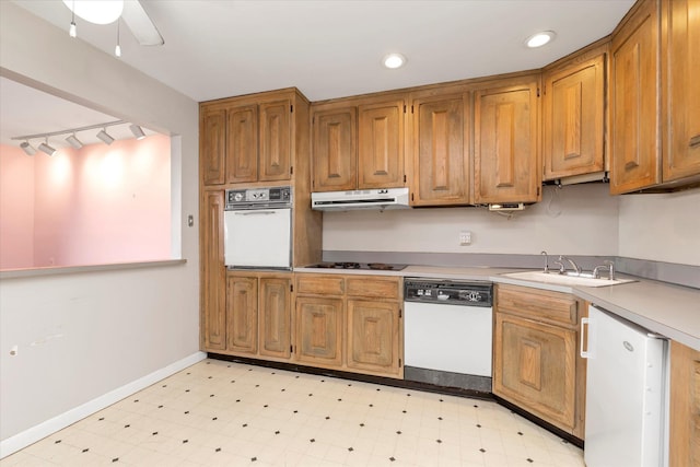 kitchen featuring brown cabinetry, white appliances, light countertops, and under cabinet range hood