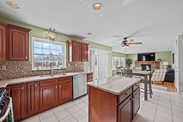 kitchen featuring open floor plan, appliances with stainless steel finishes, light tile patterned floors, and a sink