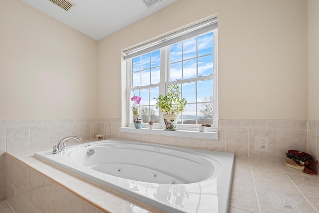 bathroom with a tub with jets and visible vents