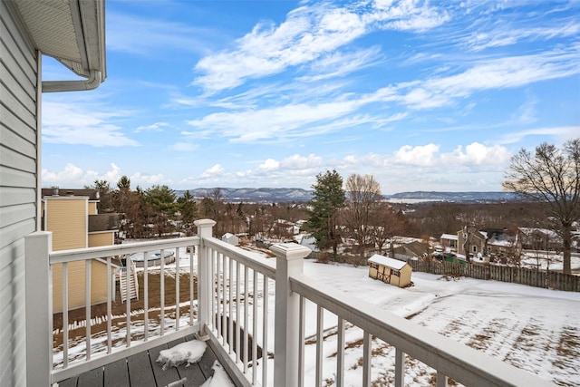 snow covered back of property featuring a mountain view