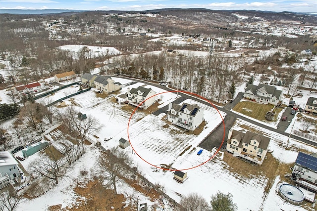 snowy aerial view featuring a mountain view and a residential view