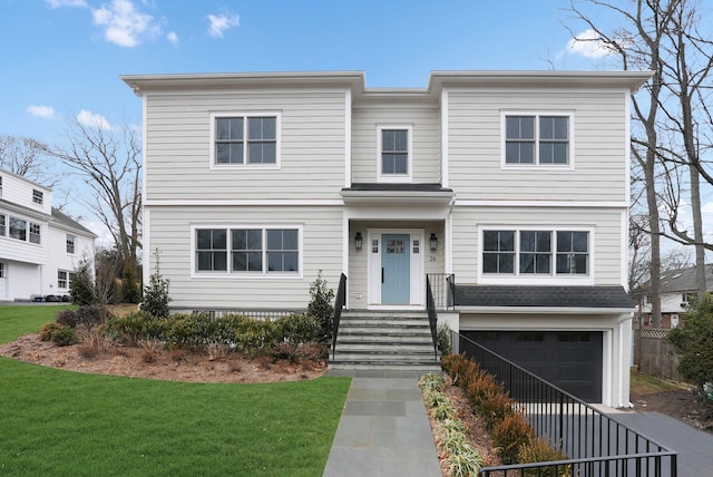 view of front of house with an attached garage and a front yard