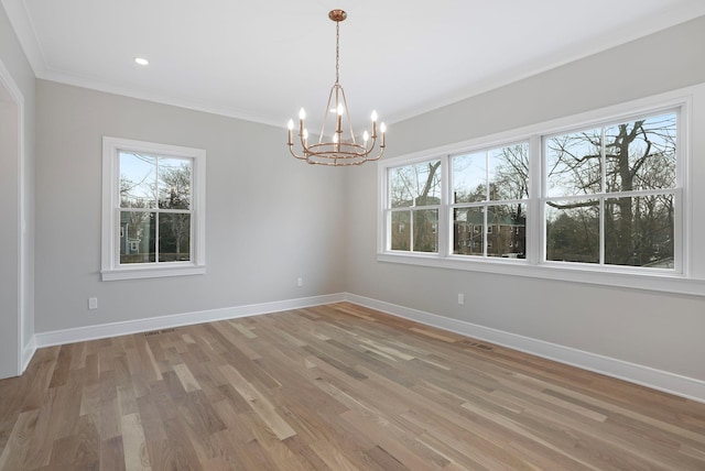 unfurnished room featuring a notable chandelier, visible vents, ornamental molding, light wood-type flooring, and baseboards