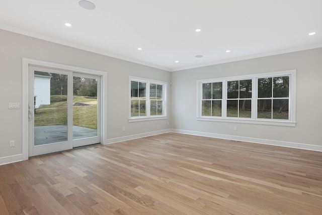 empty room with ornamental molding, recessed lighting, light wood-style flooring, and baseboards