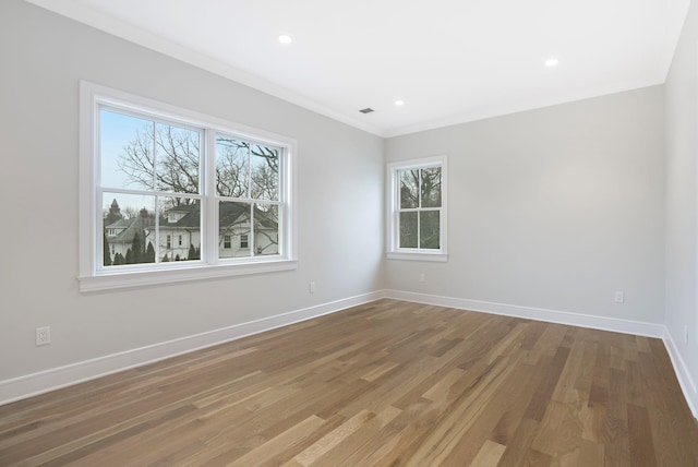 unfurnished room featuring ornamental molding, recessed lighting, wood finished floors, and baseboards